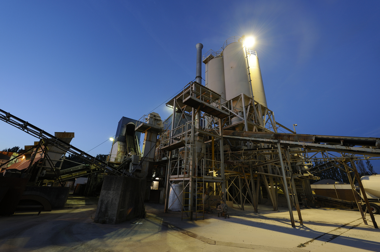 Asphalt factory at dusk Warm mix asphalt plant at dusk showing reduced emissions and improved sustainability through warm mix additives.