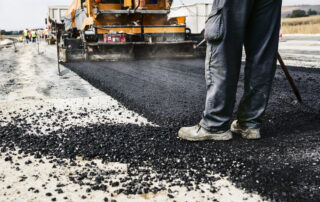 Freshly laid warm mix asphalt at a road construction site, demonstrating improved workability and sustainable paving practices.