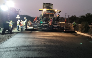 A paving crew lays down a new roadway surface in India to address high-traffic performance by using an PMB blend dosed with PGXpand.