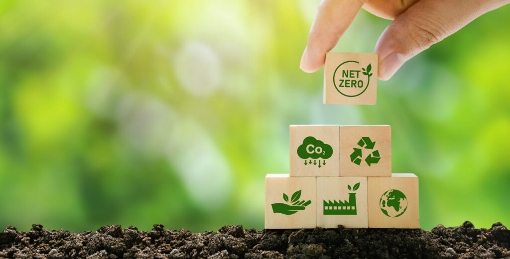 Net Zero and Neutral Carbon Footprint concepts visually represented as building blocks supported by effective asphalt rejuvenation for high-RAP content to reduce energy and emissions. 