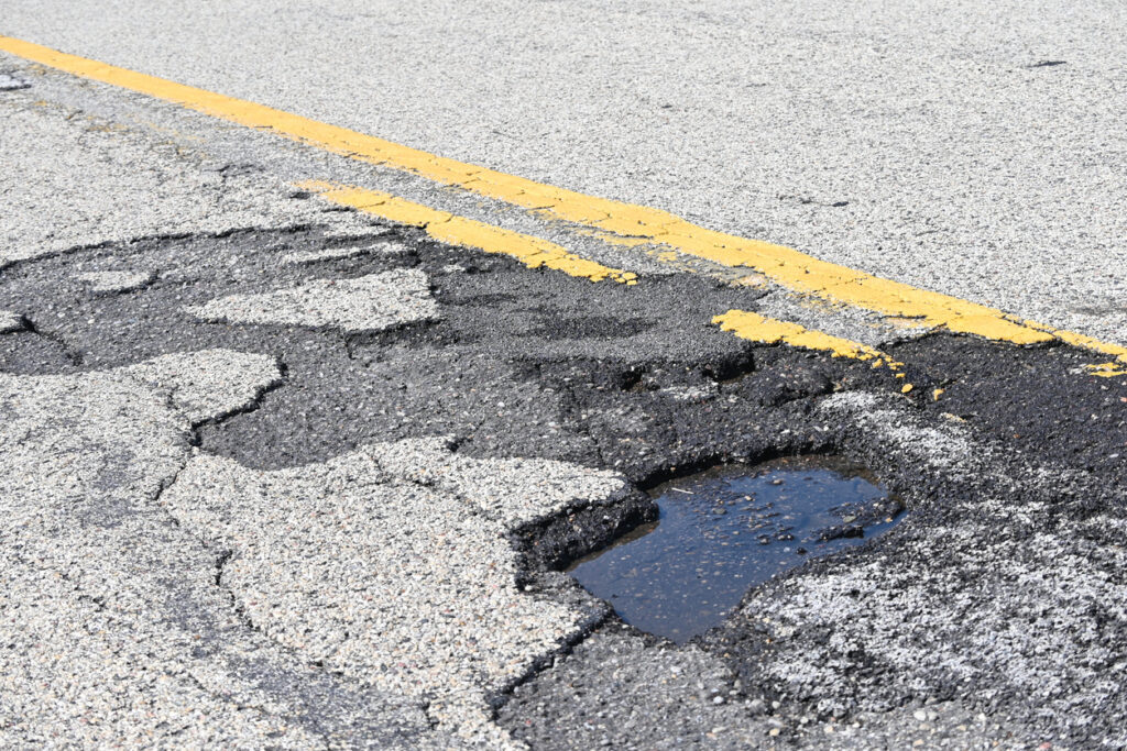 Asphalt roadway with pothole highlighting repair and maintenance needs.