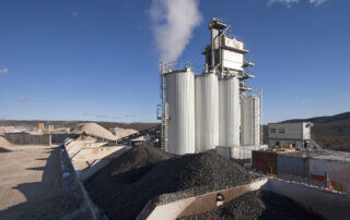 Industrial asphalt plant illustrating polymer modified bitumen production and modern crosslinking additives used in pavement materials.