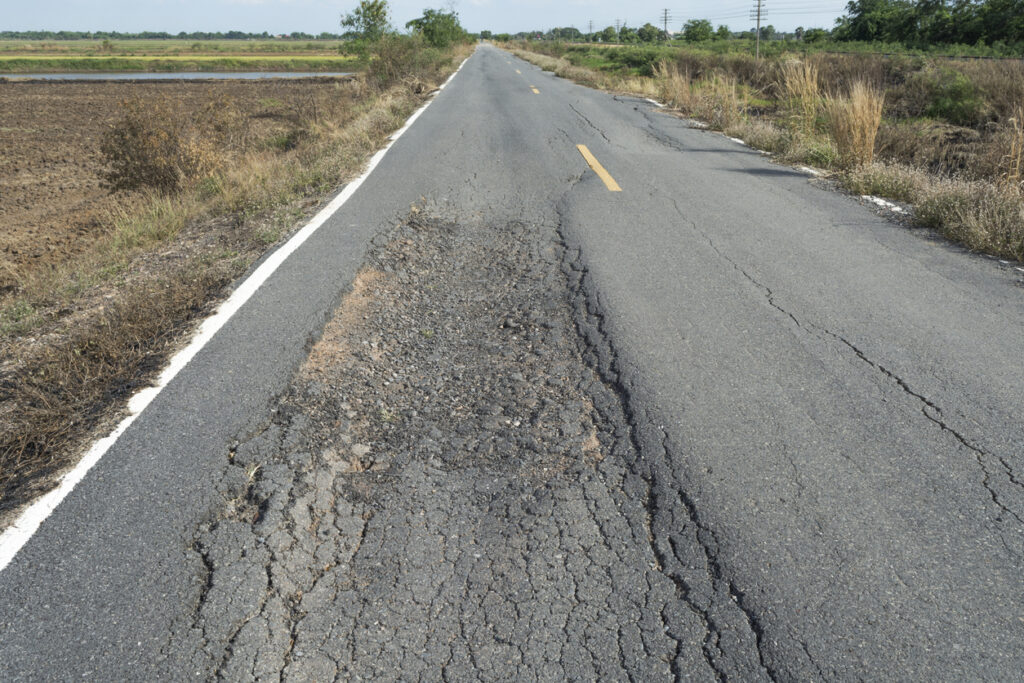 Asphalt surface on the street Asphalt roadways surface deformed over time due to the impact of traffic and environmental conditions.
