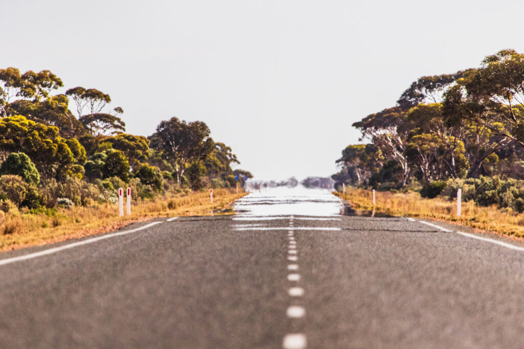 Heat refracting off a desert road to create a mirage Heat refracting off a desert road creating a mirage, illustrating high-temperature asphalt conditions and extreme heat effects on roadway surfaces.